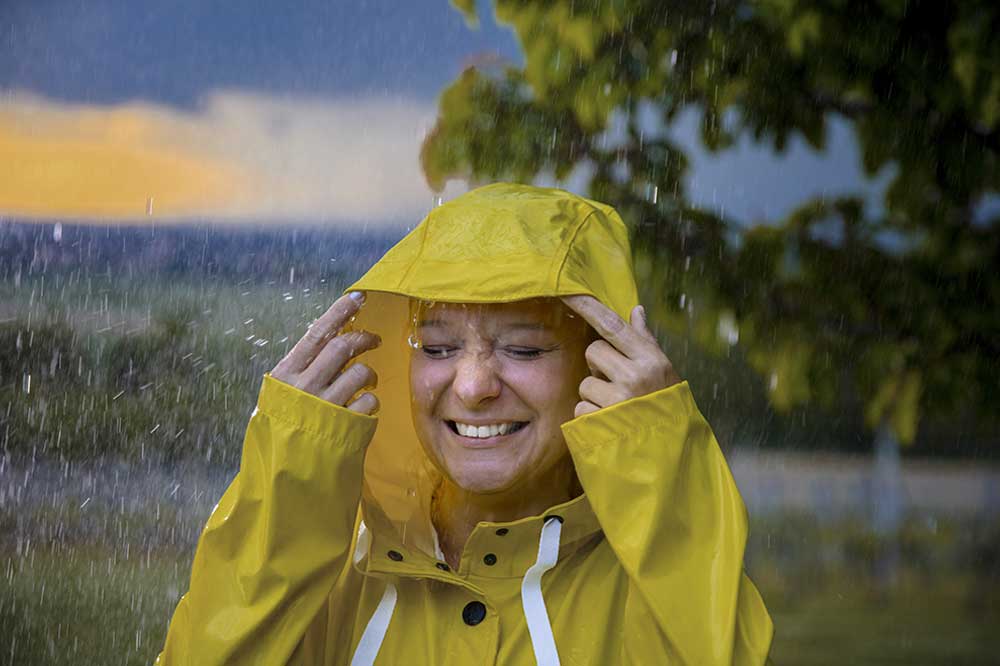 4-smiling-woman-in-a-yellow-raincoat-iStock-1284789450